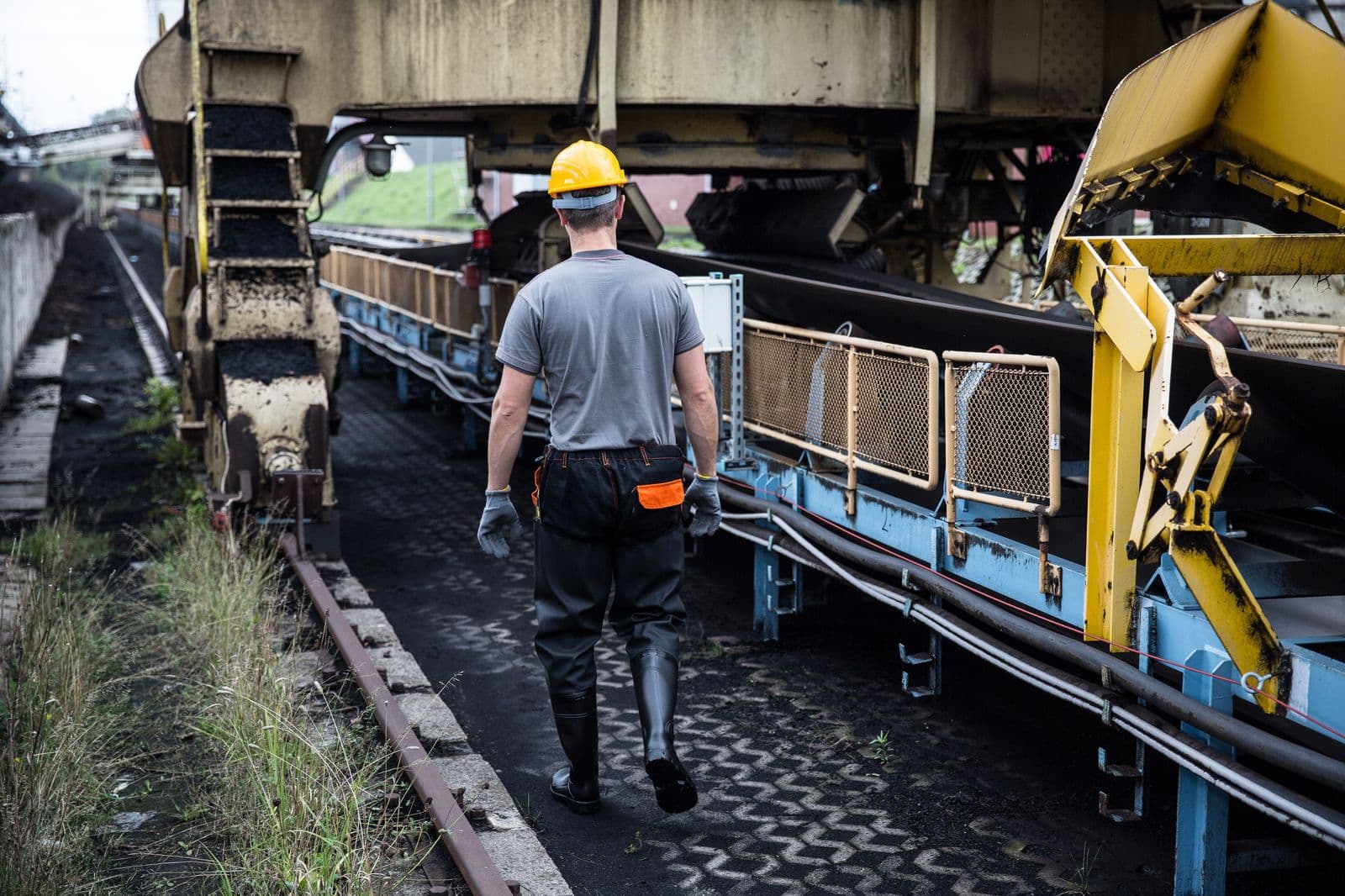 Industriarbeider med hjelm og verneutstyr på en industriarbeidsplass.